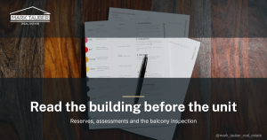 An HOA document package open on a wooden table with a pen resting on it, the paperwork a San Mateo County condo buyer reviews before writing an offer